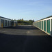 single story metal self storage buildings with metal roll-up doors and paved parking