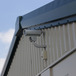 a security camera mounted on the size of a single story metal storage building