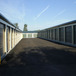 two rows of metal roll up self storage units on either side of a paved parking area