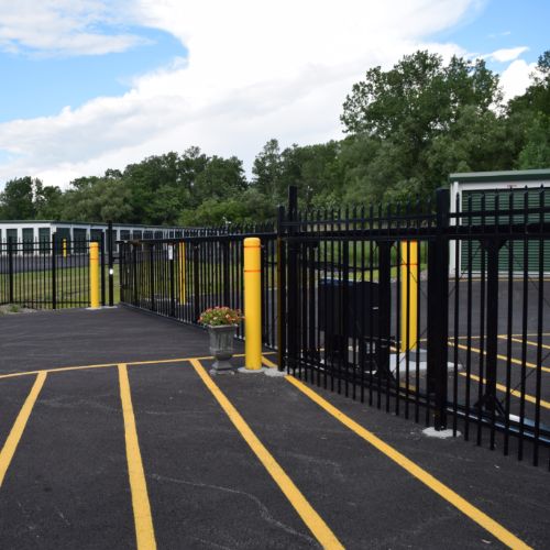 self storage units behind a pin-code activated gate under a clear blue sky