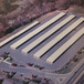 aerial photography of five single story self storage buildings surrounded by wide paved parking lanes