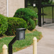 a security gate pin-pad with bollards on either side of the pin-pad, and a
      locked security gate in the background