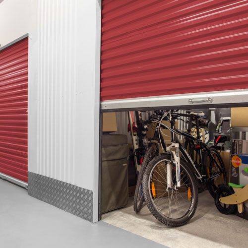 indoor climate controlled storage units with roll-up doors inside of a clean, well-lit building