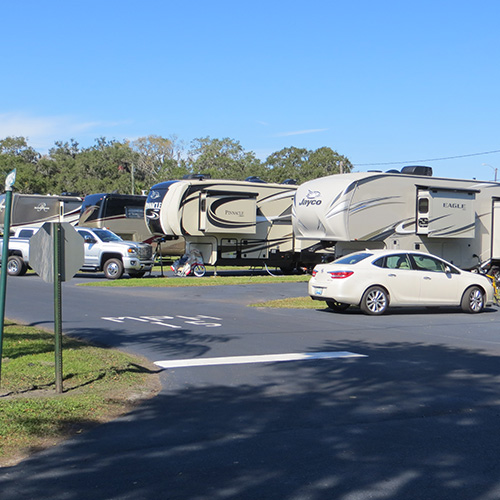  photograph of several recreational vehicles parked on grass with paved roadways running between the units